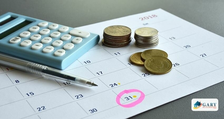 A calendar with coins, a calculator, and a pen were placed on the table.