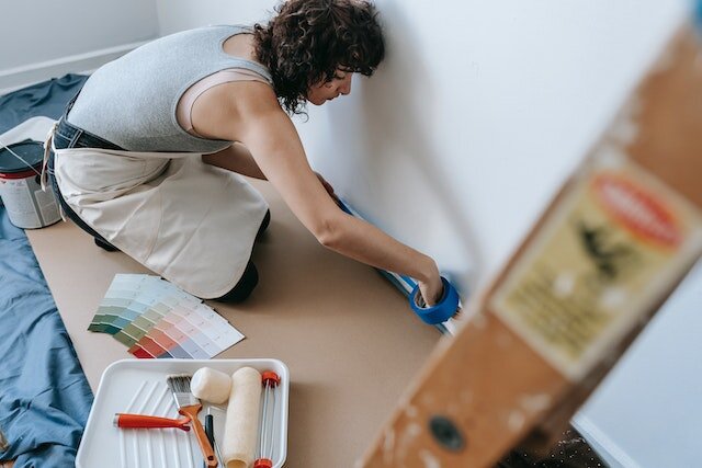 A woman preparing to add a fresh coat of paint to a wall.