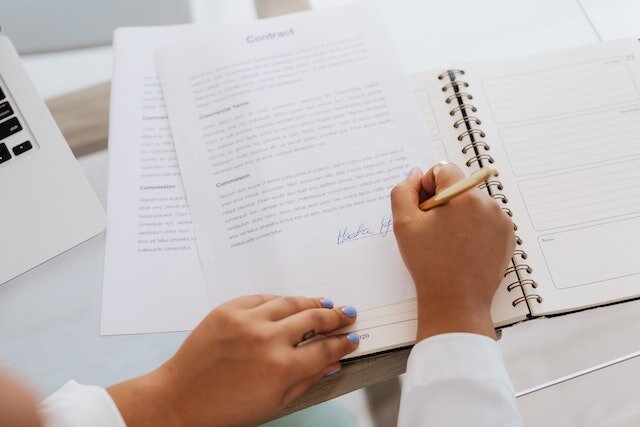 A set of hands signing a contract because they inherited a home in Orange County, NC.