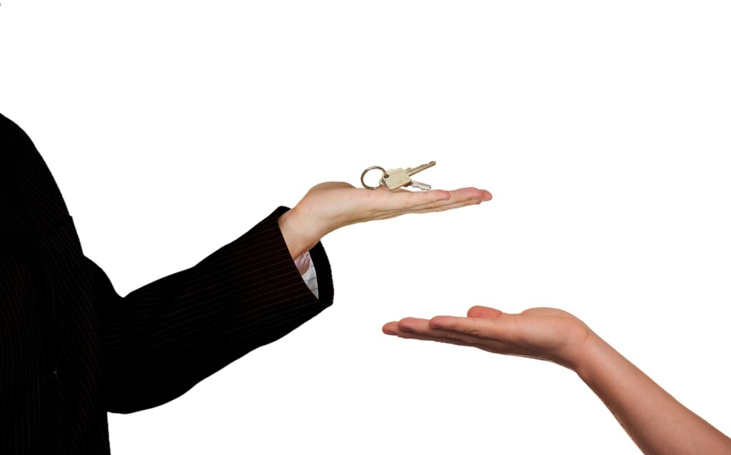 one person hands another the keys to the house