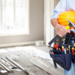 Handyman with a tool belt and repair materials as background