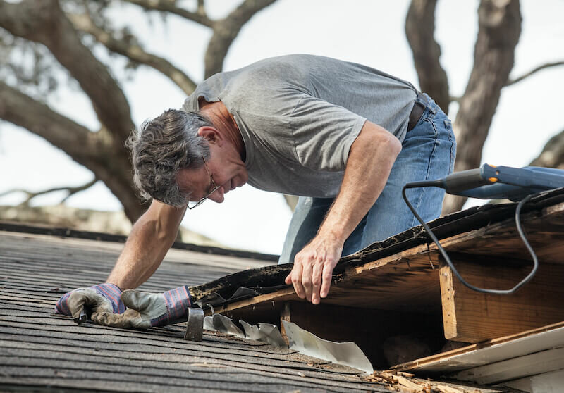 Close up view of man repairing leaky roof