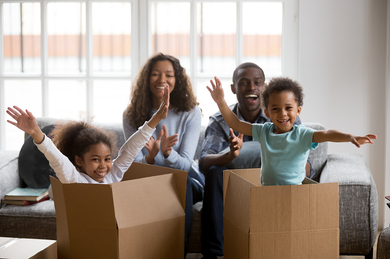 A family of homeowners playing with their moving boxes after deciding to sell their property 