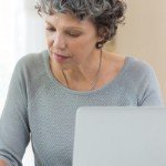 buying investment property with a partner | woman on computer