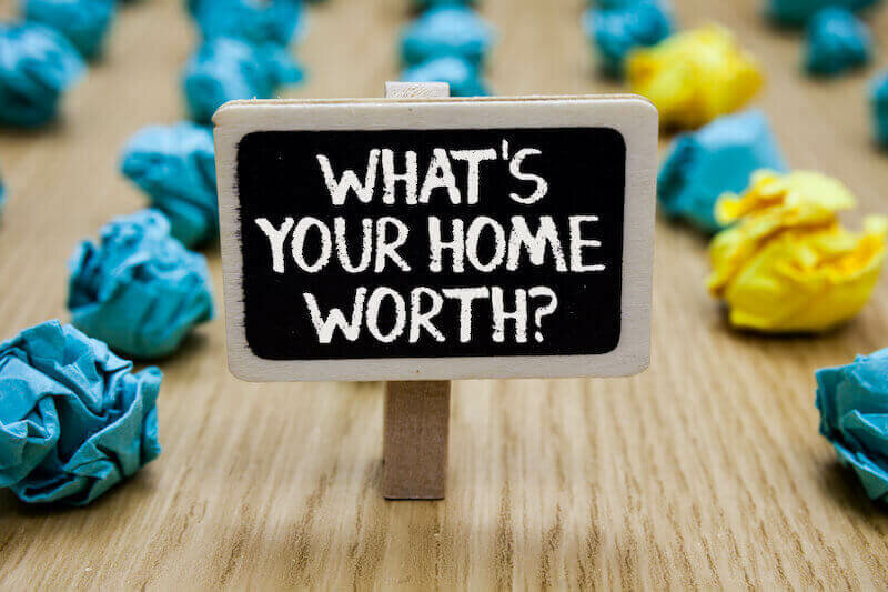 sign on table whats your home worth with crumpled papers