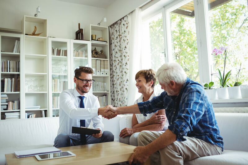 couple talking to a representative of a house buying company