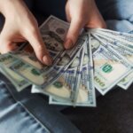 person holding bundle of cash