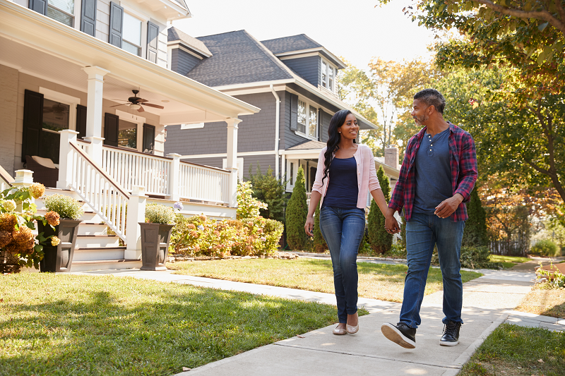 A couple holding hands and walking through a neighborhood in Camden, New Jersey