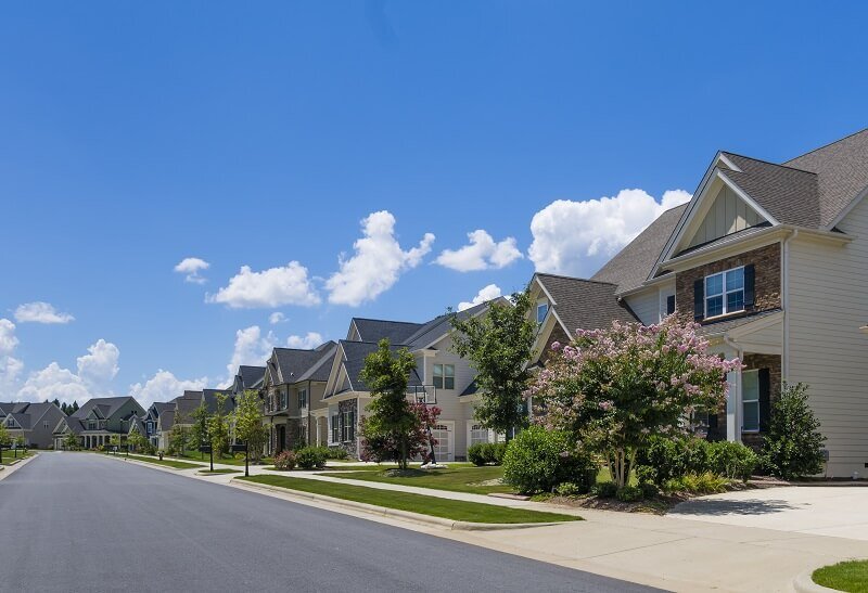 A row of houses in a beautiful suburban neighborhood with a clear blue sky in the background