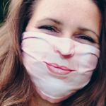 woman smiling with mask on who is moving during coronavirus