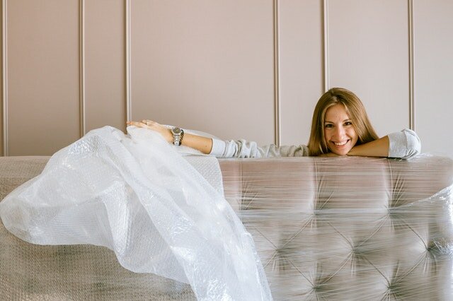 A woman unpacking her bed in her new home

