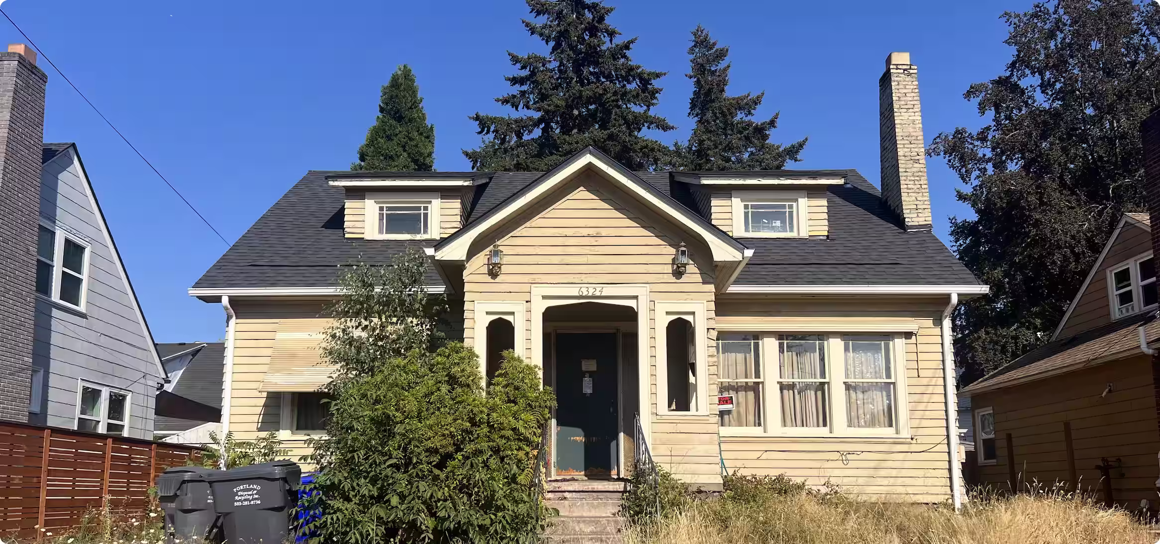 Two-story beige craftsman house in Portland, Oregon with wood siding and a brick chimney.