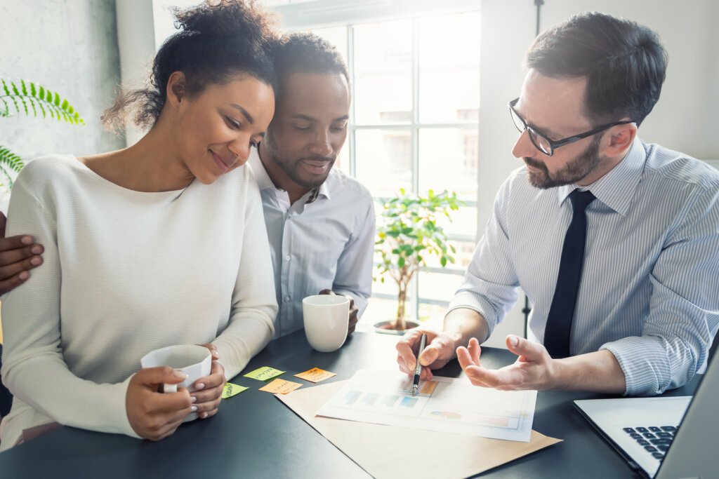 Couple reviewing home sales numbers with purchasing agent