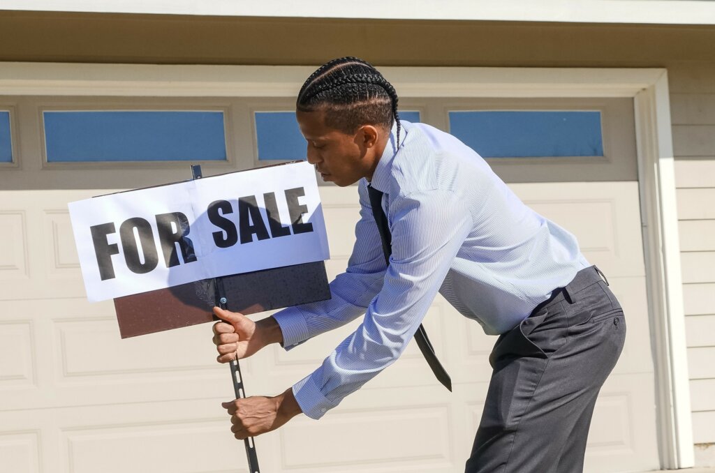 real estate agent placing a for sale sign