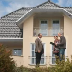 Estimate agent with potencial buyers in front of house