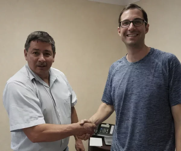 Carlos Escobar shakes hands with Josh Cohen inside the 3 Step Home Sale office after selling his Fairfax, VA home in 21 days as he prepares for retirement.