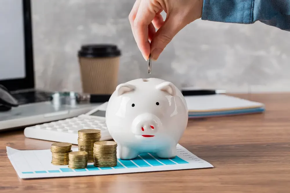 man putting a penny in a piggy bank