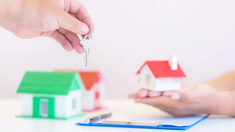 a person handing a house key to another person