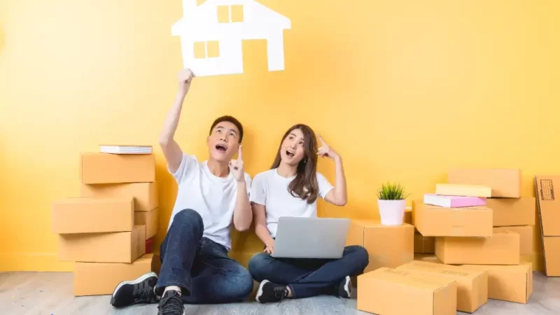 a man and a woman sitting on the floor with a laptop