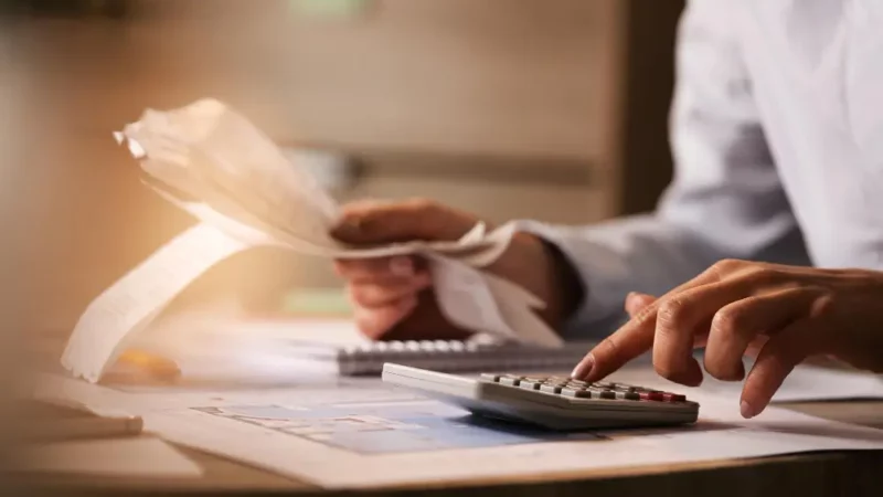 a person using a calculator on a desk