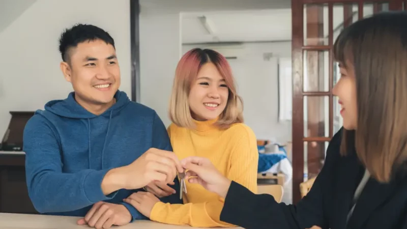 Asian couple shaking hands with an agent