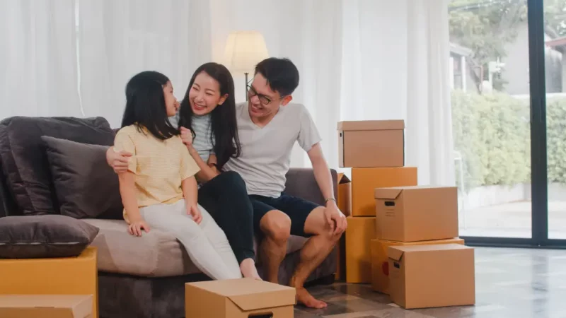 family of three sitting down with brown boxes