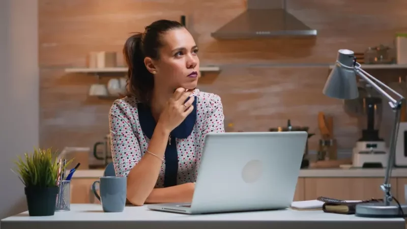Woman thinking with laptop in front of her