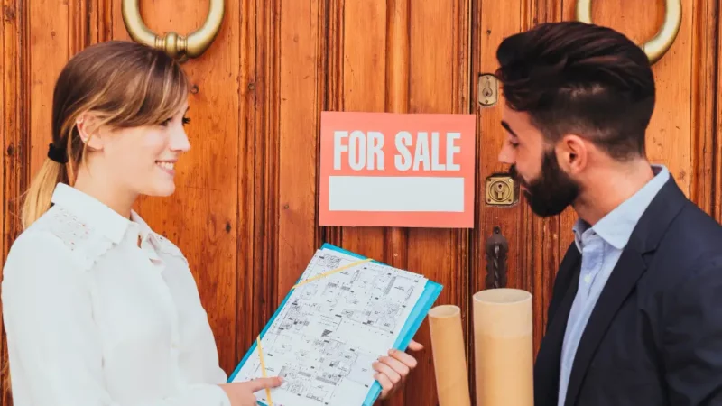 A woman selling a man a house