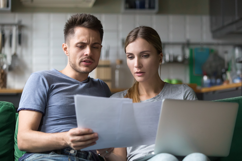 Photo of a young couple analyzing the house selling feels that they'll have to pay to sell their home in Texas