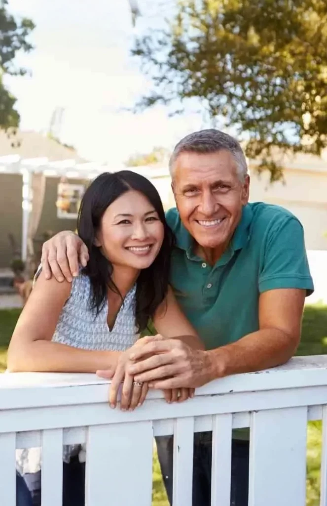 couples standing leaning on the fence