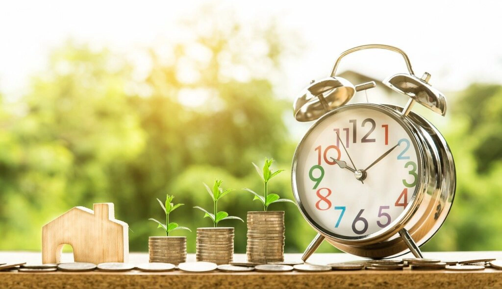 Model house, clock, and coins symbolizing the time and costs of selling an inherited house in South Carolina