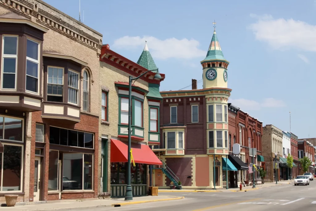 Historic downtown street in New Berlin with colorful brick buildings and a clock tower under a clear sky.