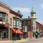 Historic downtown street in New Berlin with colorful brick buildings and a clock tower under a clear sky.