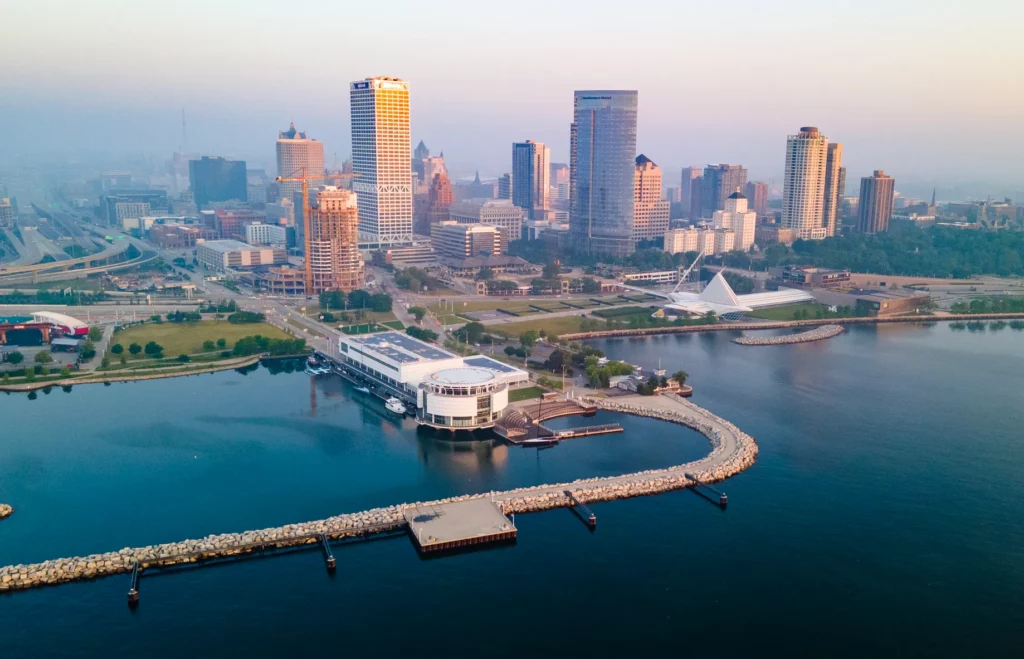 Aerial view of downtown Milwaukee skyline at sunrise over Lake Michigan.