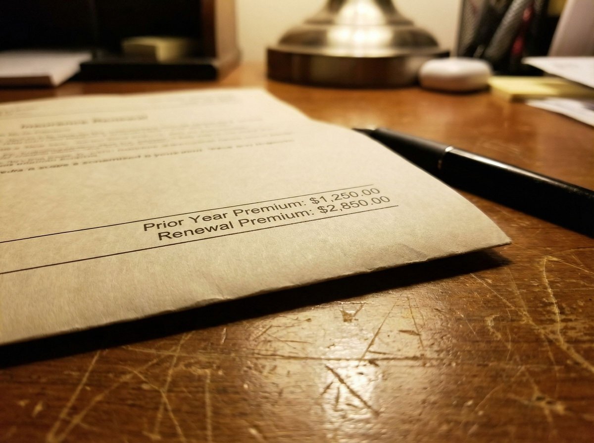 Insurance renewal notice with significant premium increase on kitchen table — Buffalo NY homeowner insurance too expensive